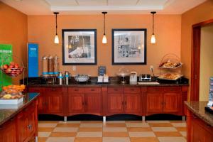 a kitchen with orange walls and wooden cabinets at Hampton Inn Evanston in Evanston