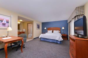 a hotel room with a bed and a flat screen tv at Hampton Inn Evanston in Evanston