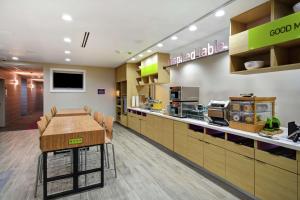 a kitchen with a table and chairs in a restaurant at Home2 Suites By Hilton Fort Worth Fossil Creek in Fort Worth