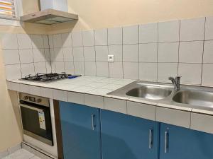 a kitchen with a sink and a stove at La Belle Escapade in Quartier du Fond Fleuri