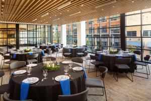 a conference room with tables and chairs and windows at Canopy By Hilton Grand Rapids Downtown in Grand Rapids