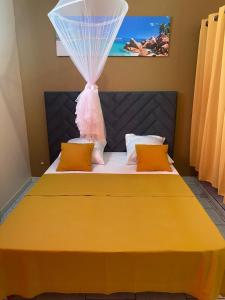 a bedroom with a yellow bed with a dress on it at La Belle Escapade in Quartier du Fond Fleuri