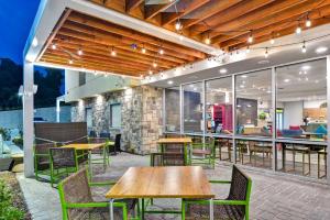an outdoor patio with wooden tables and chairs at Home2 Suites By Hilton Hot Springs in Hot Springs