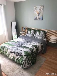um quarto com uma cama com um edredão verde e branco em Big flat Brest em Brest