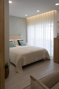 塞辛布拉的住宿－Casa Lumar - Sesimbra，一间卧室设有一张大床和一个大窗户