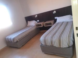 twee bedden in een hotelkamer met een sidx sidx sidx sidx bij Complejo familia Yedynak in San Rafael