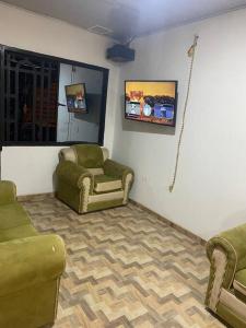 ein Wohnzimmer mit 2 Stühlen und einem TV in der Unterkunft Confortable Apartamento Central in Tame