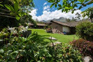 ein Hof mit einem Haus und ein paar Blumen in der Unterkunft Kawsay- Hospedaje y Alimentacion in Ibarra