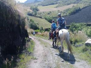 イバラにあるKawsay- Hospedaje y Alimentacionの未舗装の馬に乗る二人