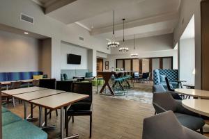 een lobby met tafels en stoelen en een eetkamer bij Hampton Inn & Suites By Hilton Southport in Southport