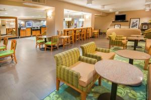 a waiting room with tables and chairs in a hospital at Hampton Inn Lafayette Louisiana in Scott