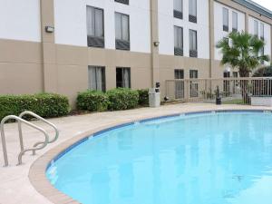 een groot blauw zwembad voor een gebouw bij Hampton Inn Lafayette Louisiana in Scott