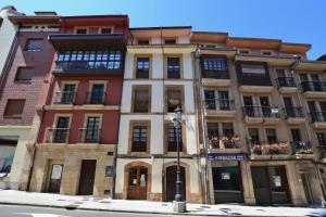 ein hohes Gebäude mit Balkonen und einer Straßenecke in der Unterkunft STAY Rosal in Oviedo