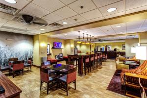 a restaurant with tables and chairs and a bar at Hampton Inn Junction City in Junction City