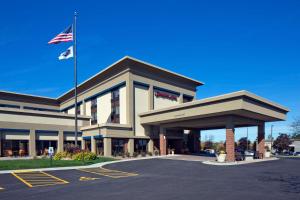 an office building with an american flag in a parking lot at Hampton Inn Milwaukee Brookfield in Brookfield