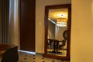 a mirror in a room with a table and a chandelier at Hotel Scappata in Progreso