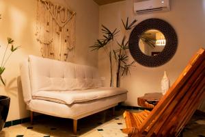 a living room with a white chair and a mirror at Hotel Scappata in Progreso