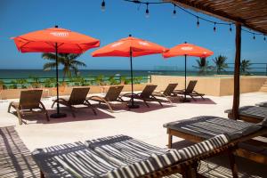 a group of tables and chairs with umbrellas on the beach at Hotel Scappata in Progreso