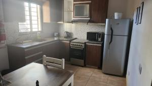 a kitchen with a refrigerator and a table in it at DEPARTAMENTOS CIELO DE CAFAYATE in Cafayate