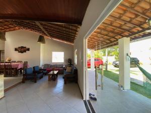 ein Wohnzimmer mit einem Sofa und einem Tisch in der Unterkunft Casa Cantinho de Arembepe - Linda casa com piscina no litoral norte da Bahia in Camaçari