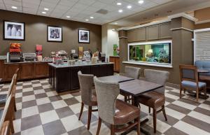 a restaurant with a table and chairs and a counter at Hampton Inn Myrtle Beach Broadway at the Beach in Myrtle Beach