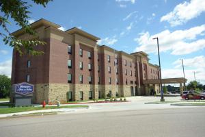 een groot bakstenen gebouw op een straat met een parkeerplaats bij Hampton Inn & Suites Oklahoma City/Quail Springs in Oklahoma City