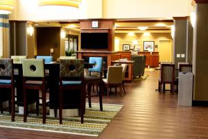 uma sala de jantar com mesas e cadeiras e uma televisão em Hampton Inn & Suites Paducah em Paducah