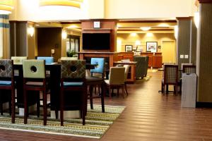 a dining room with tables and chairs and a television at Hampton Inn & Suites Paducah in Paducah