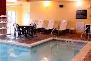 a pool with chairs and a table and a restaurant at Hampton Inn & Suites Paducah in Paducah