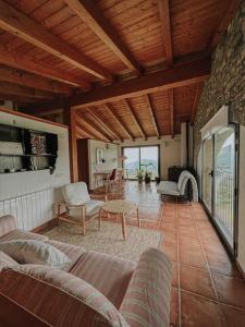 La casa de la masia في Susqueda: غرفة معيشة فيها أريكة وكراسي