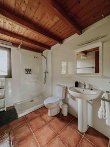 a bathroom with a toilet and a sink and a tub at La casa de la masia in Susqueda