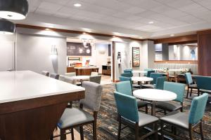 a waiting room with tables and chairs in a restaurant at Hampton Inn Council Bluffs in Council Bluffs