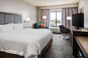 una camera d'albergo con letto e TV di Hampton Inn Council Bluffs a Council Bluffs