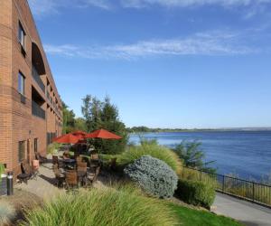 eine Terrasse mit Tischen und Stühlen und Blick auf das Wasser in der Unterkunft Hampton Inn Richland-Tri Cities in Richland