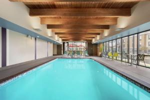 a large swimming pool with blue water in a building at Home2 Suites By Hilton Warminster Horsham in Warminster