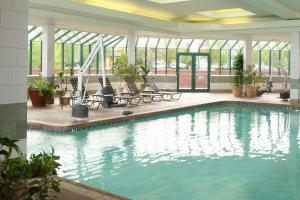 ein großer Pool in einem Gebäude mit Tischen und Stühlen in der Unterkunft Hampton Inn Richland-Tri Cities in Richland