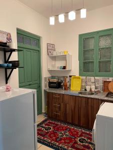 - une cuisine avec des portes vertes et un comptoir dans l'établissement Résidence artistique Vue sur mer, à Larache