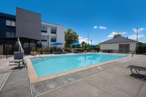 a swimming pool with chairs and a building at Hampton Inn Princeton in Princeton