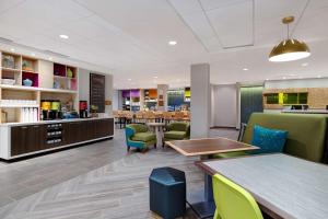 uma sala de espera num hospital com mesas e cadeiras em Home2 Suites By Hilton Redding em Redding