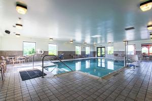 a large swimming pool in a room with tables and chairs at Hampton Inn Pine Grove in Pine Grove