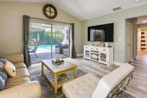 a living room with a couch and a tv at Bonita Springs Home with Pool - 2 Mi to Beach! in Bonita Springs