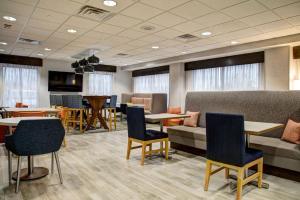 a waiting room with tables and chairs and a couch at Hampton Inn Rochester in Rochester
