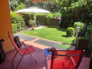 dwa krzesła i parasol na patio w obiekcie Holiday-Home-Desenzano w mieście Desenzano del Garda