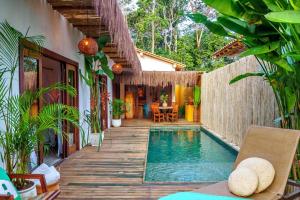 a house with a swimming pool and a wooden deck at Casa Rudá Condominio Icatu in Trancoso