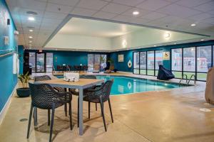 a pool room with a table and chairs and a swimming pool at Hampton Inn Rochester in Rochester