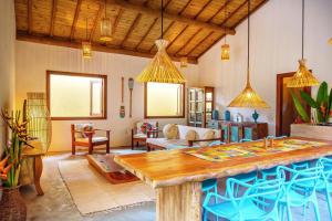 a large living room with a large wooden table at Casa Rudá Condominio Icatu in Trancoso