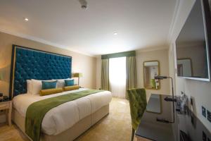 Best Western Abbots Barton Hotel في كانتربيري: غرفة نوم مع سرير كبير مع اللوح الأمامي الأزرق