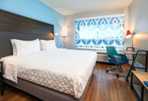 a bedroom with a bed and a desk and a chair at Tru By Hilton Wichita Falls, Tx in Wichita Falls