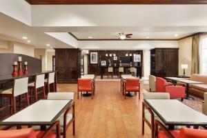 a restaurant with tables and chairs and a bar at Hampton Inn Sulphur Springs in Sulphur Springs