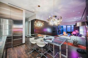 a kitchen with a dining table and a living room at Intimo Palms Place Penthouse in Las Vegas